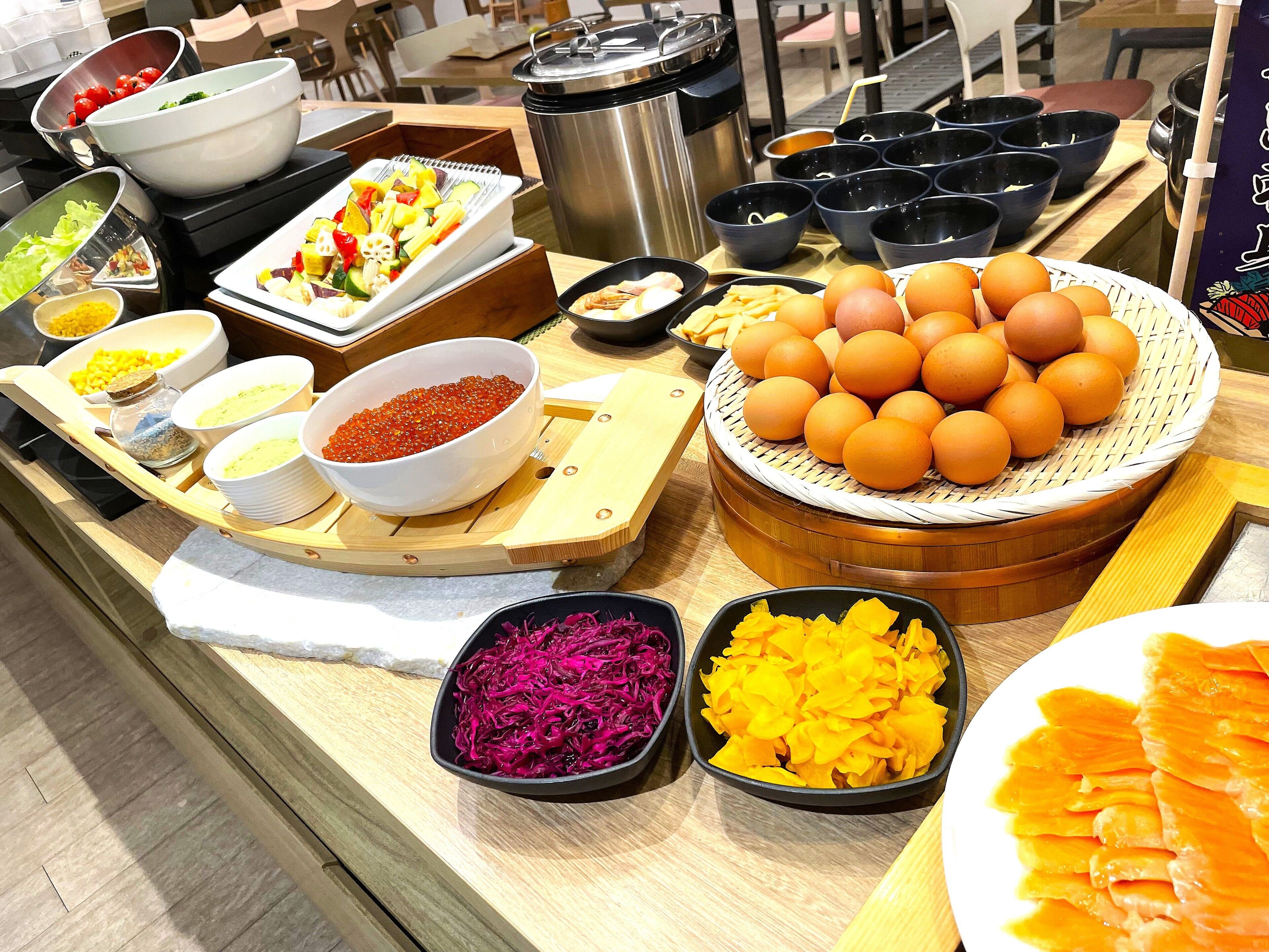 A buffet with various food items including fruits, vegetables, and eggs.
