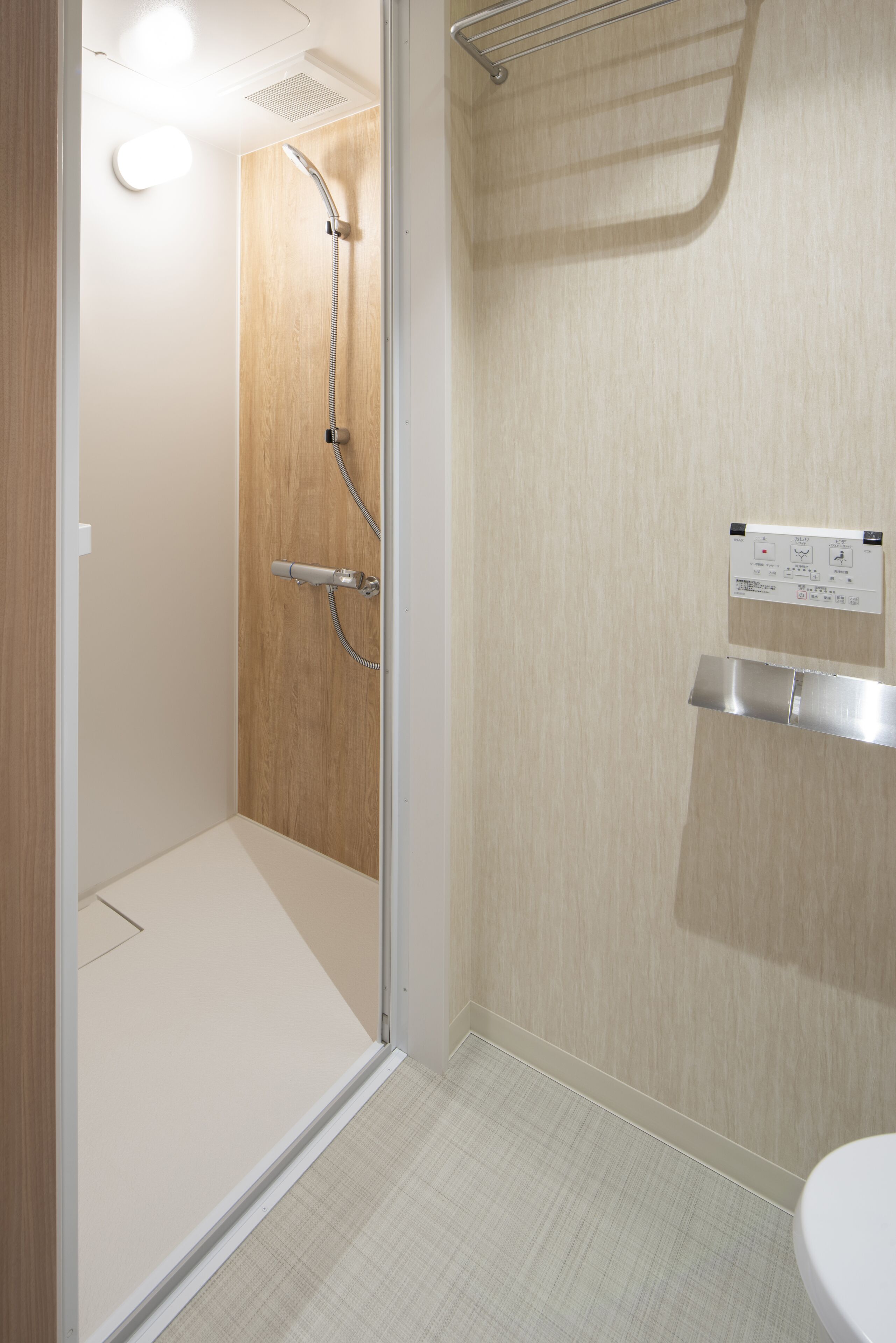 Ein modernes Badezimmer mit Dusche, Toilette und Handtuchhalter.