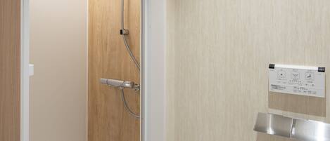 A modern bathroom with a shower, a toilet, and a towel rack.