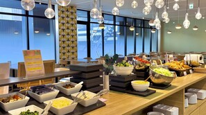 Un buffet proposant une variété de plats et un panneau indiquant le menu.
