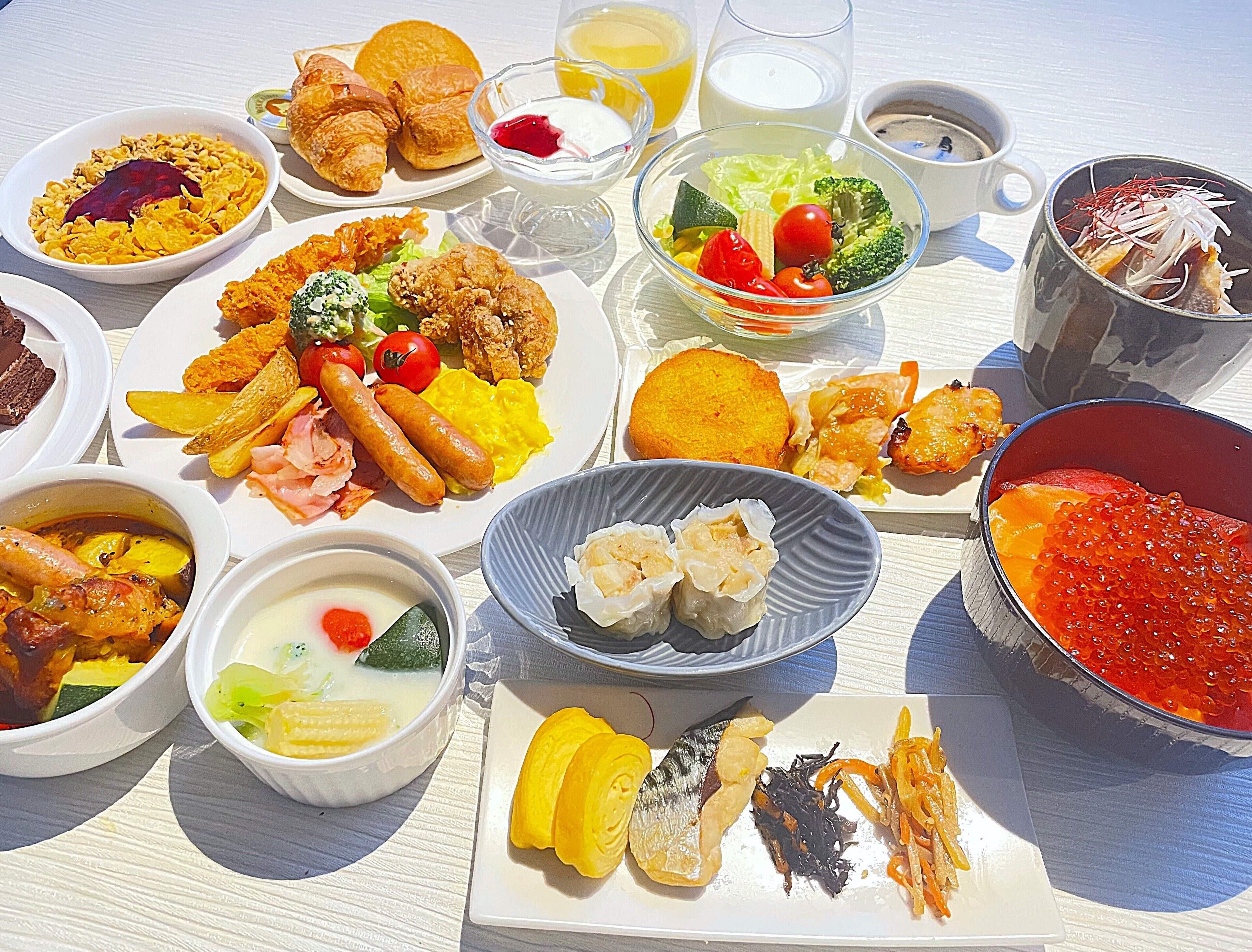 A table set with various dishes including seafood, vegetables, and bread.