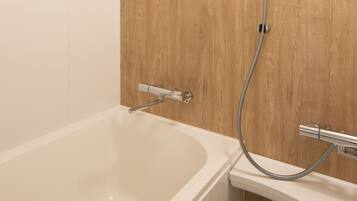 A modern bathroom with a wooden wall, a white bathtub, and a separate shower area.