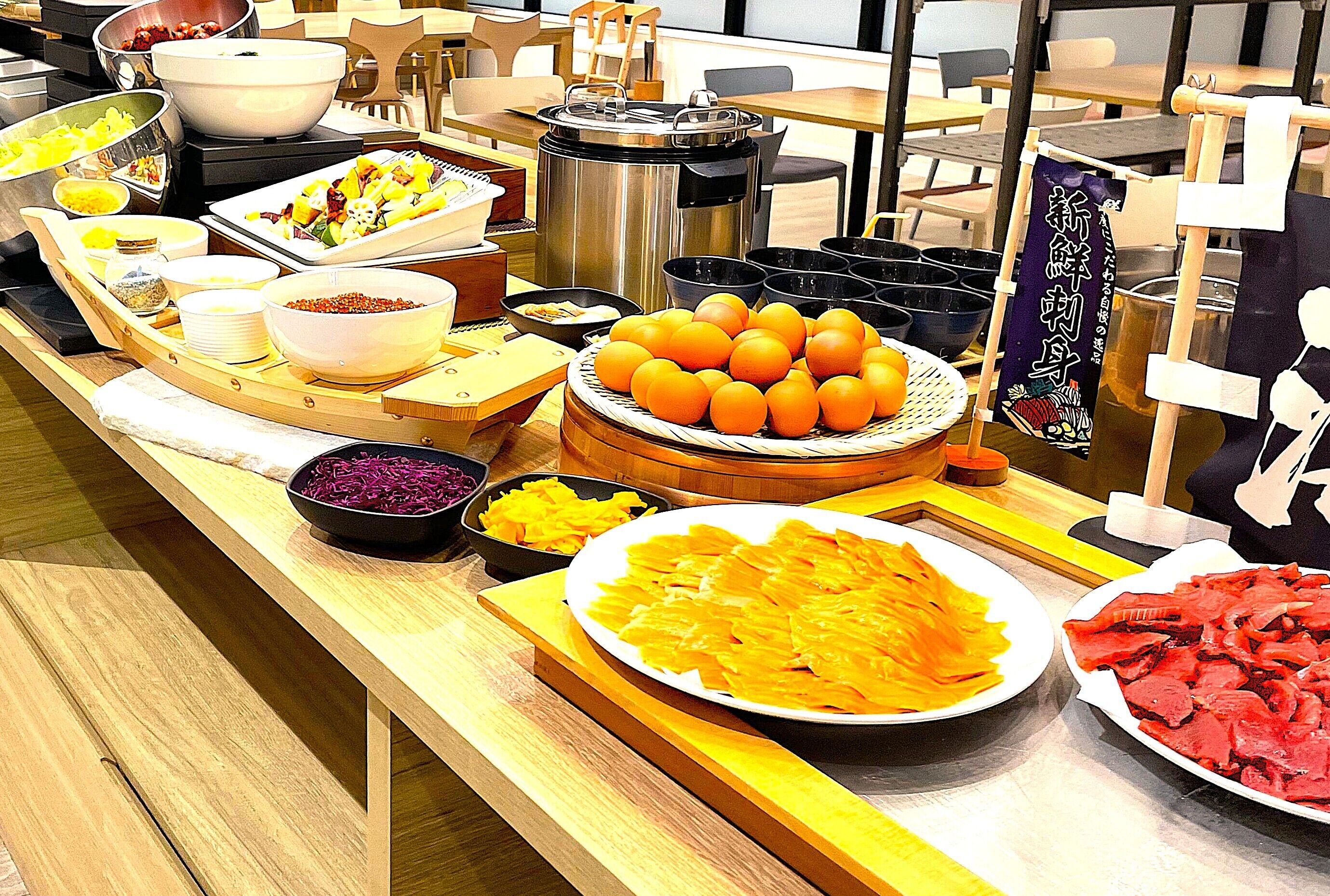Ein Buffet mit verschiedenen Speisen, darunter Orangen, ein Schälchen Rotkohl und eine Platte mit Aufschnitt.
