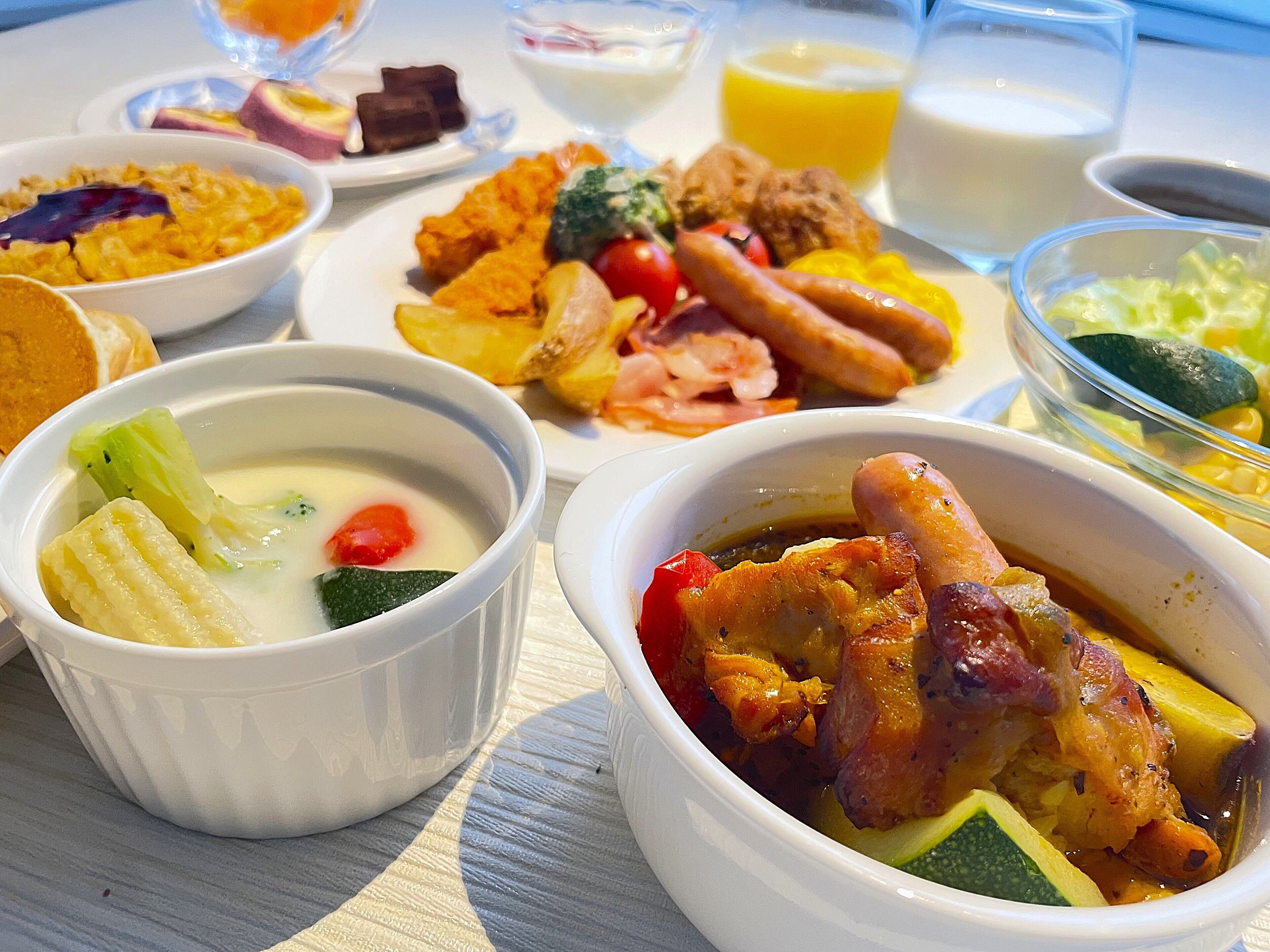 Una mesa con diversos platos, incluyendo sopa, carne, verduras y pan.