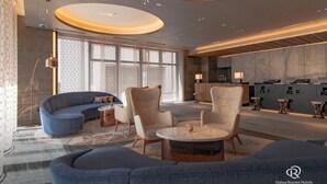 Un moderno vestíbulo de hotel con una zona de estar, una recepción y un bar.