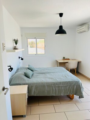 A bedroom with a bed, bedside tables, a desk, a chair, a hanging lamp, and a window. - 'Luxurious villa in the sun' with Sea & Mountain View, Pool, A/C & Wi-Fi (Mijas Costa)