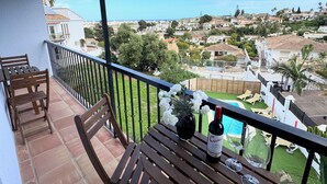 A balcony with a wooden table, a bottle of wine, and a glass. - 'Nice and Spacius Villa near Fuengi' with Sea & Mountain View, Pool, NO under 40 (Mijas)