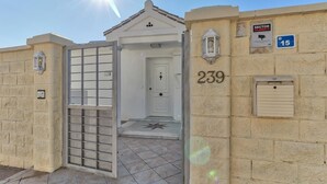 A building entrance with a gate, a door, and a wall-mounted number 239. - 'Nice and Spacius Villa near Fuengi' with Sea & Mountain View, Pool, NO under 40 (Mijas)