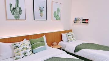 Quarto de hotel com duas camas, uma cabeceira de madeira e três quadros na parede.