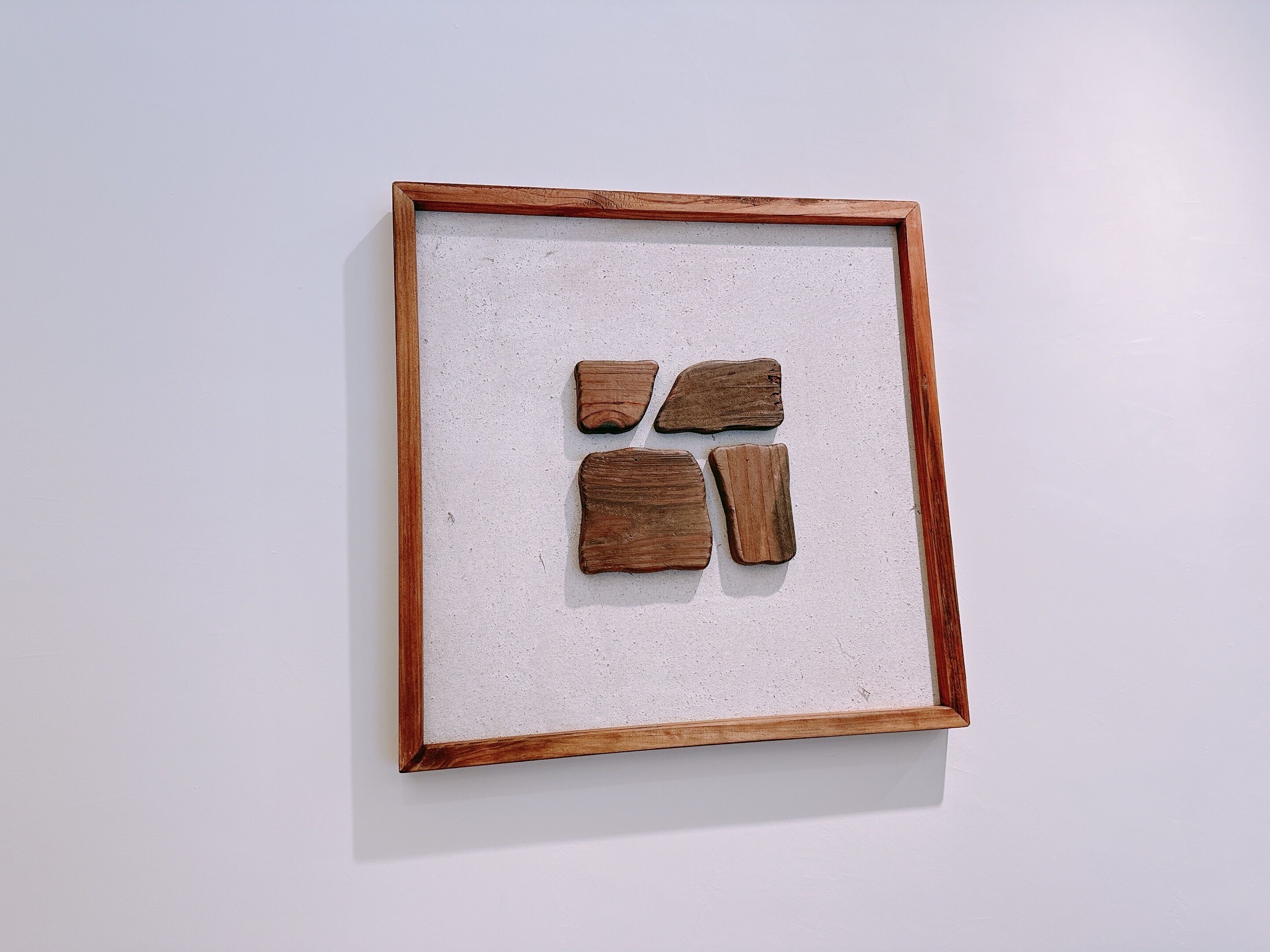 Une œuvre d’art encadrée, composée de quatre éléments rectangulaires sur un fond blanc.