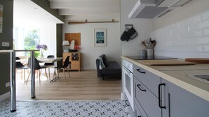 Una cocina moderna con comedor, piso de madera y vista al exterior.