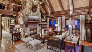 A log cabin interior with a stone fireplace, wooden beams, and rustic decor. - Eagles Nest Luxury Retreat, Views, Hot Tub, Walking distance to Resort (Sundance)