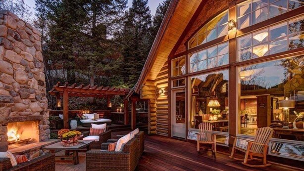 A log cabin with a stone fireplace, outdoor seating, and large windows. - Eagles Nest Luxury Retreat, Views, Hot Tub, Walking distance to Resort (Sundance)