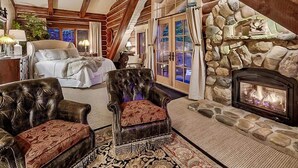 A cozy room with a fireplace, a large bed, and a leather armchair. - Eagles Nest Luxury Retreat, Views, Hot Tub, Walking distance to Resort (Sundance)