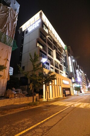 A multi-story hotel with a modern facade, large windows, and a prominent illuminated sign. - Stay-inn Hotel (Gimhae)