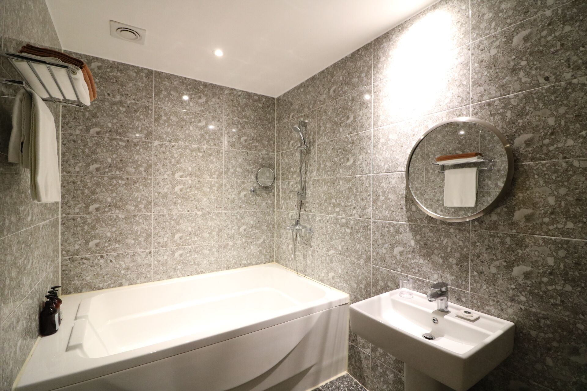 Un baño moderno con bañera, lavamanos y espejo.
