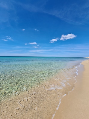 A beach with clear shallow waters and a sandy shore under a blue sky. - Beautiful villa near Torre Ovo, 800 meters from the sea. (Monacizzo-librari-truglione)