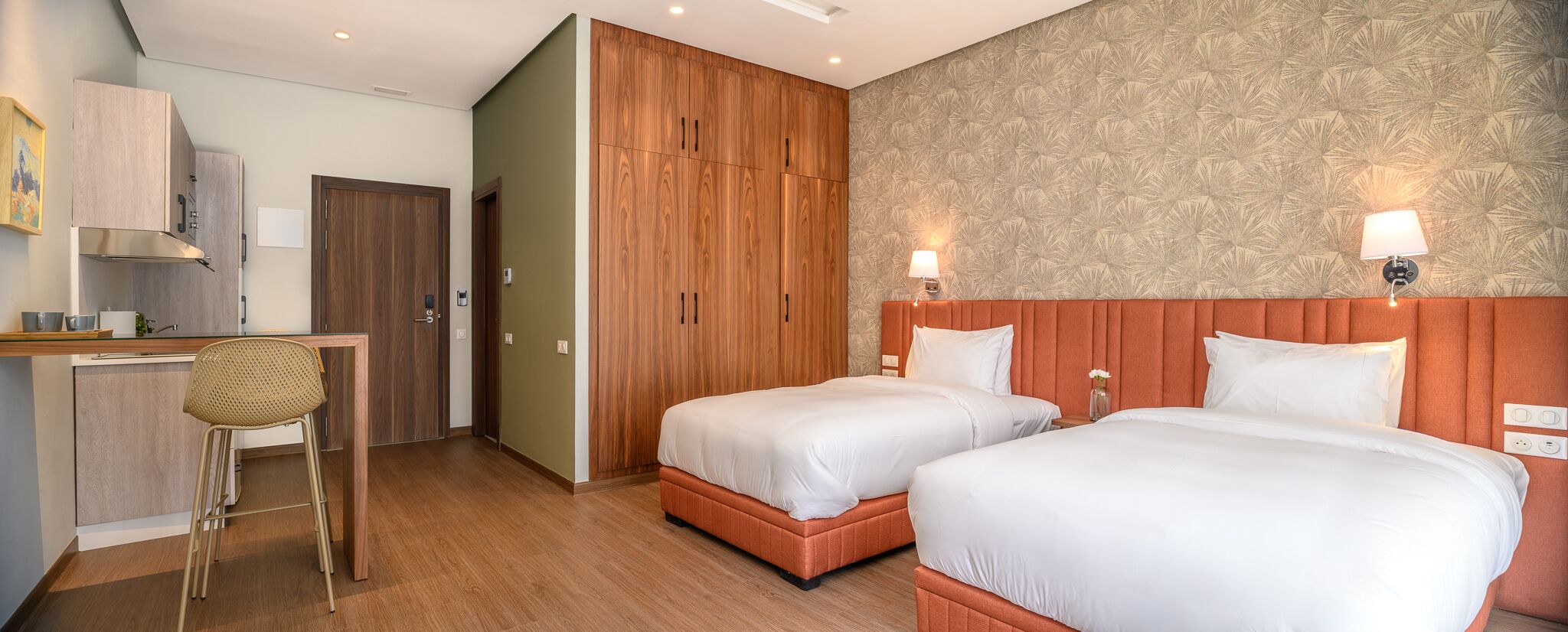 Une chambre d’hôtel avec deux lits, un bureau et une chaise.