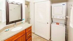 Une salle de bain avec un lavabo, un miroir, un meuble-lavabo en bois et une porte blanche.