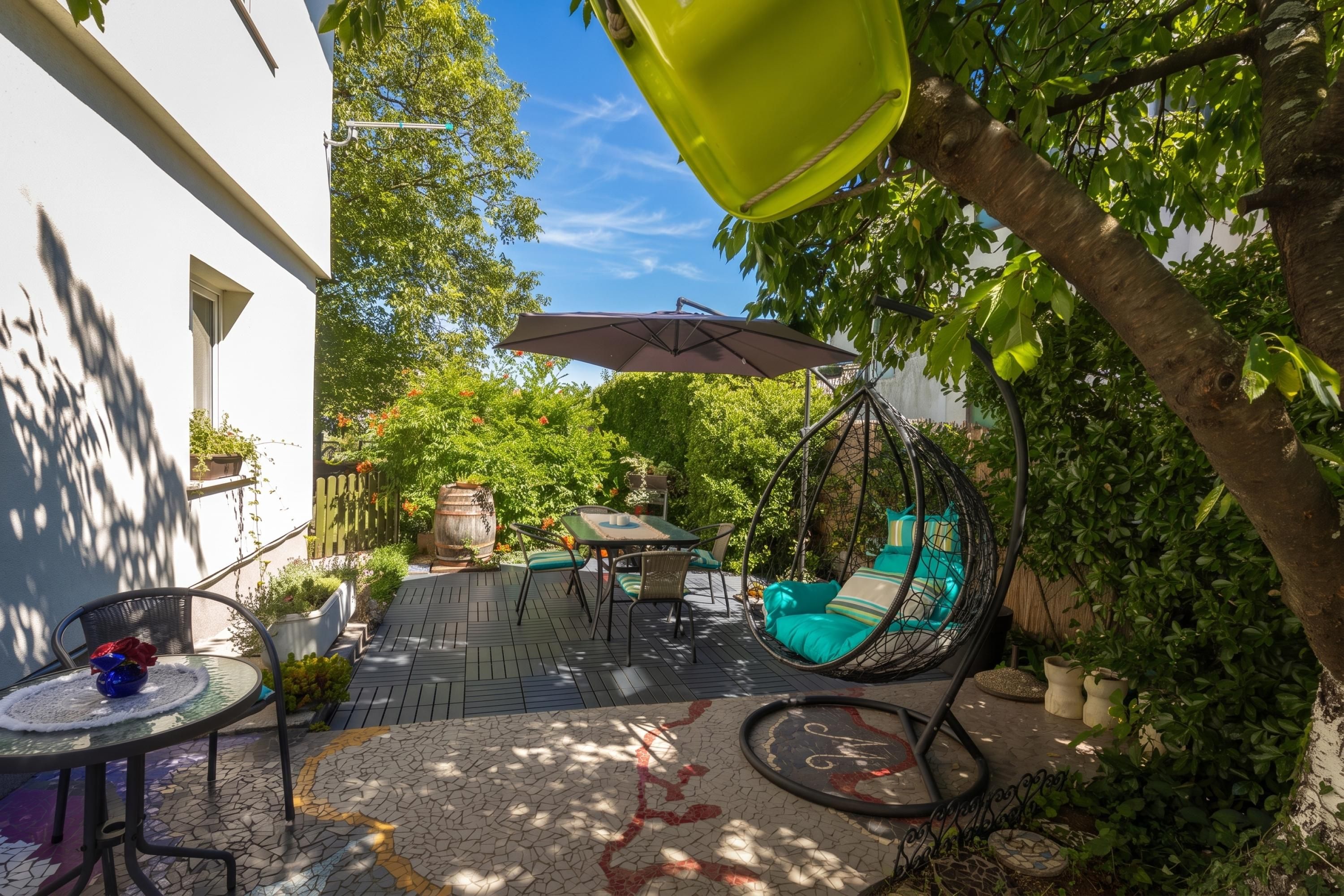A patio with a hanging chair, a table, and a hanging umbrella.