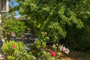 A garden with a stone pathway, potted plants, and a table with chairs. - Cozy Home With Private Garden (Jelenje)
