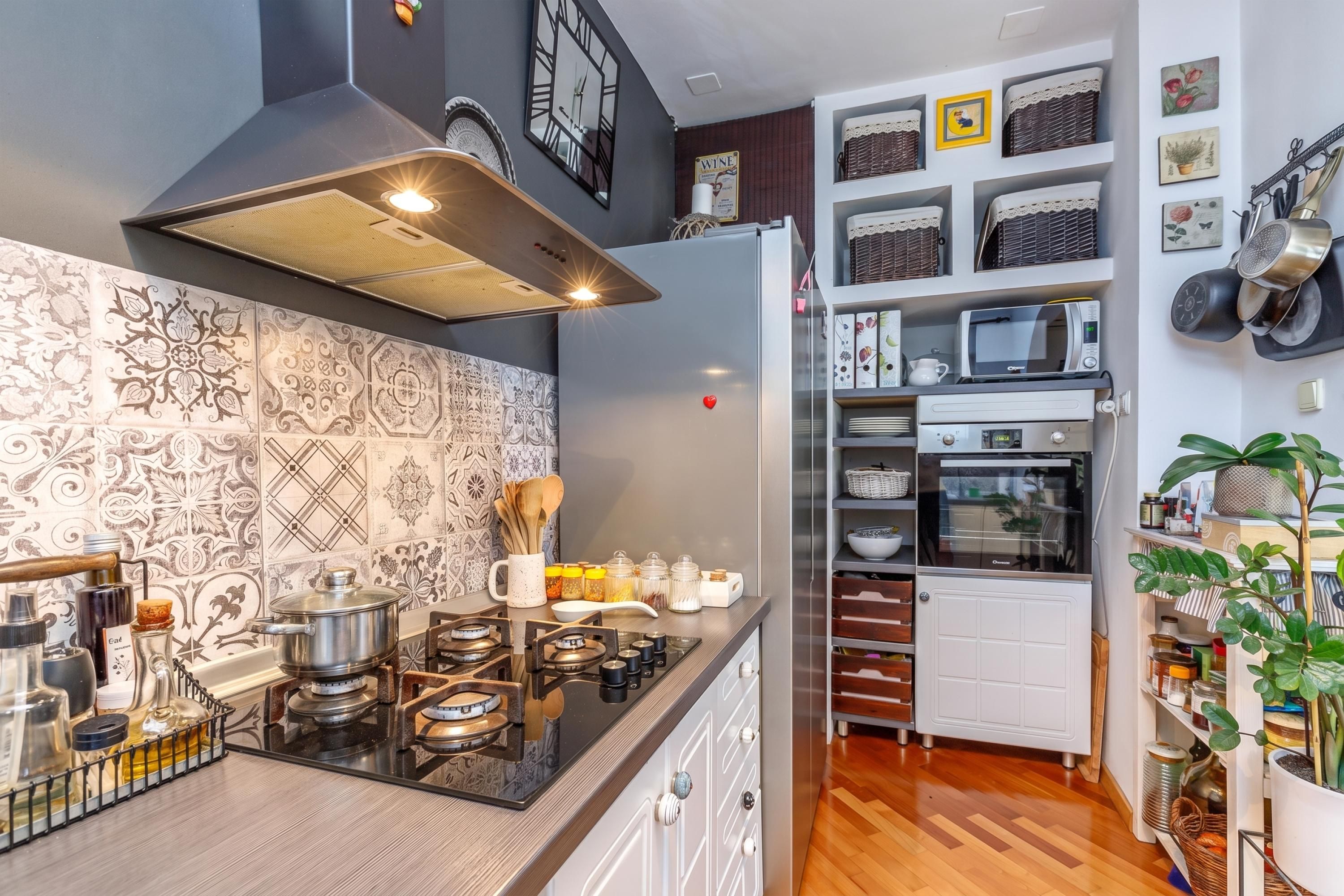 A compact kitchen with a gas stove, a built-in oven, and a microwave.