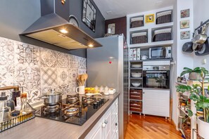 A compact kitchen with a gas stove, a built-in oven, and a microwave. - Cozy Home With Private Garden (Jelenje)