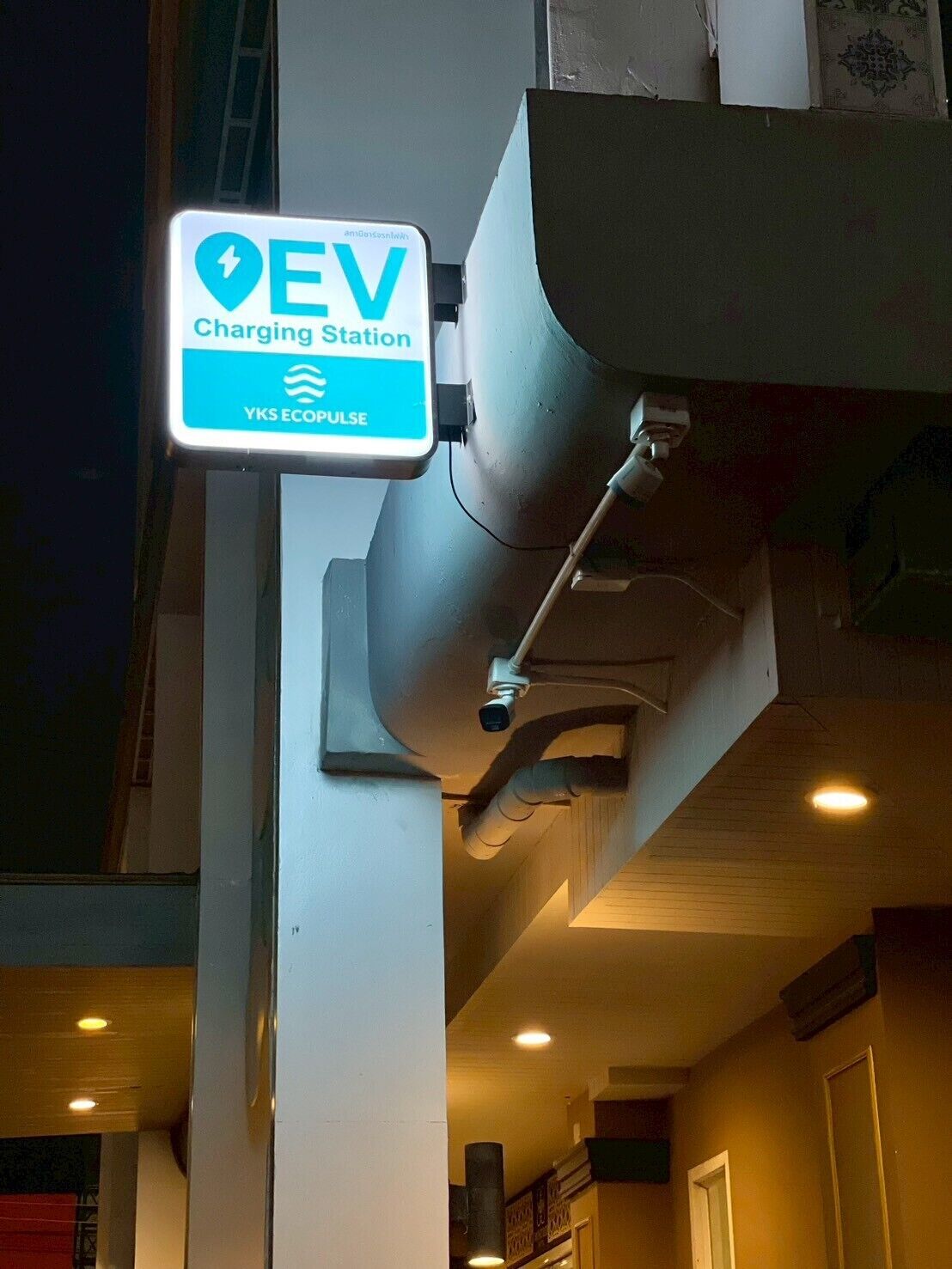 An EV Charging Station sign attached to a building.