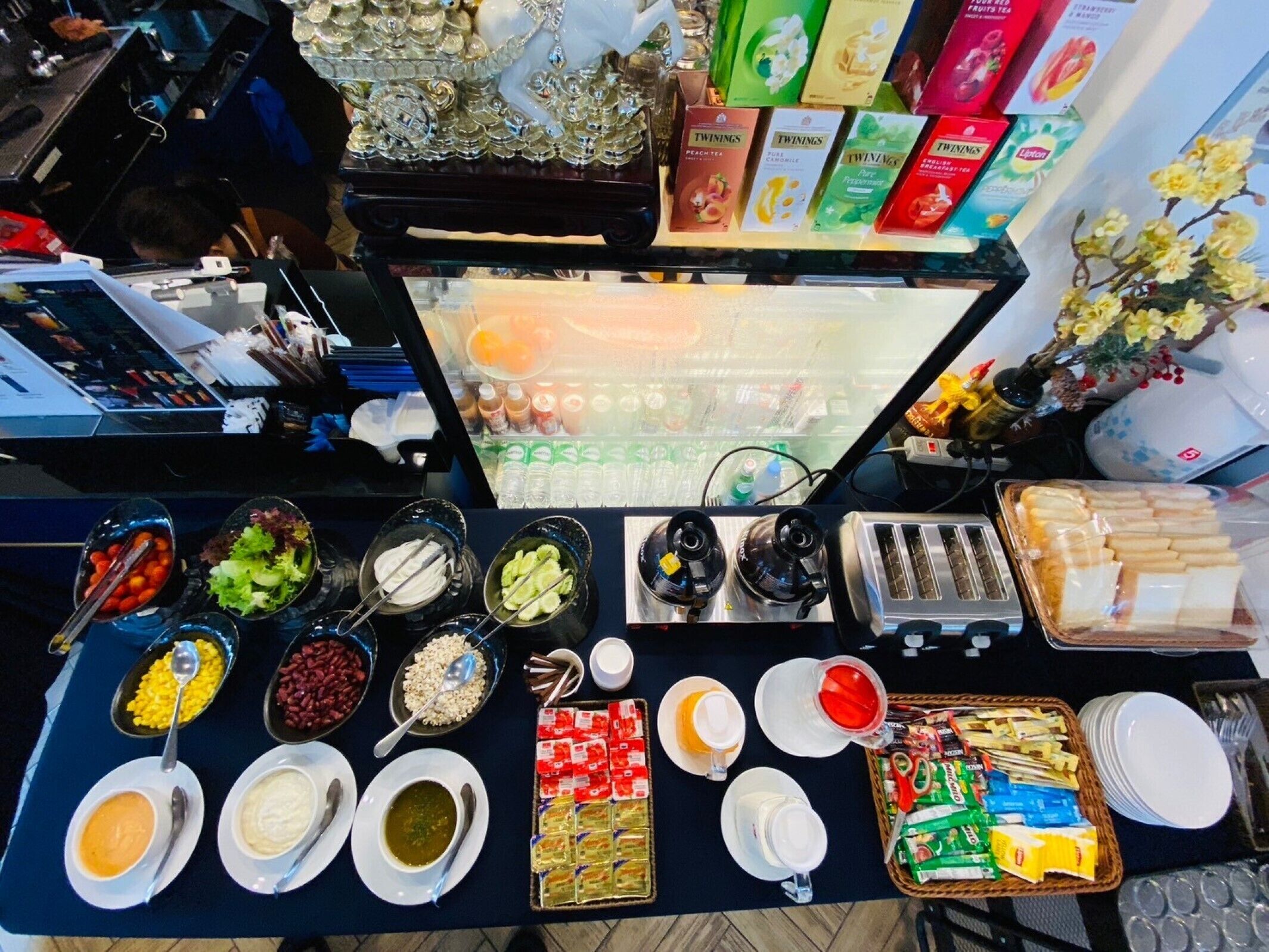 A buffet table with various food items, including fruits, vegetables, and beverages.