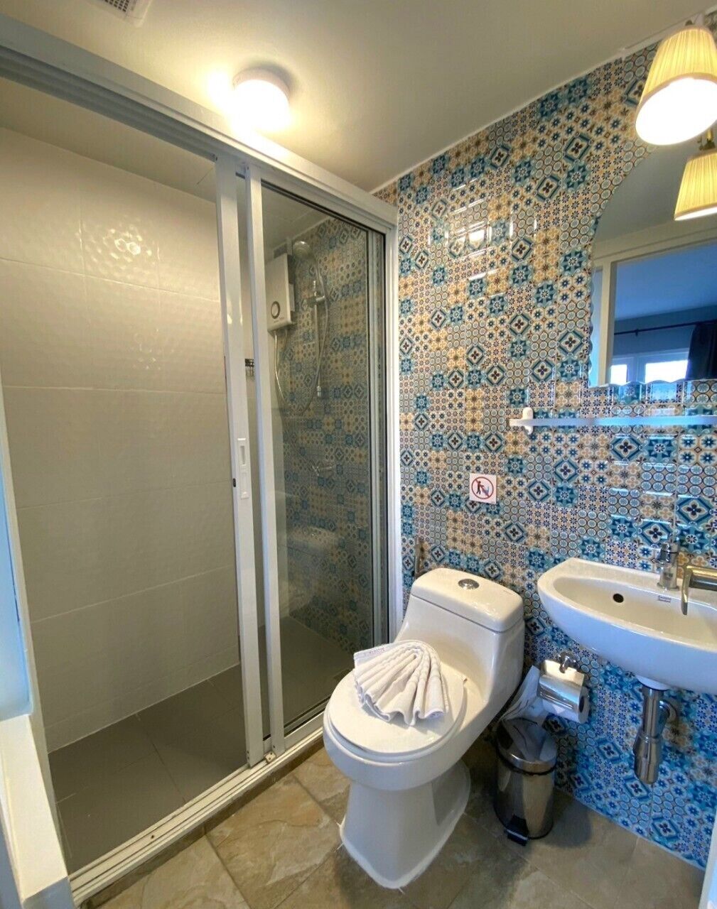 A bathroom with a shower, toilet, and sink.