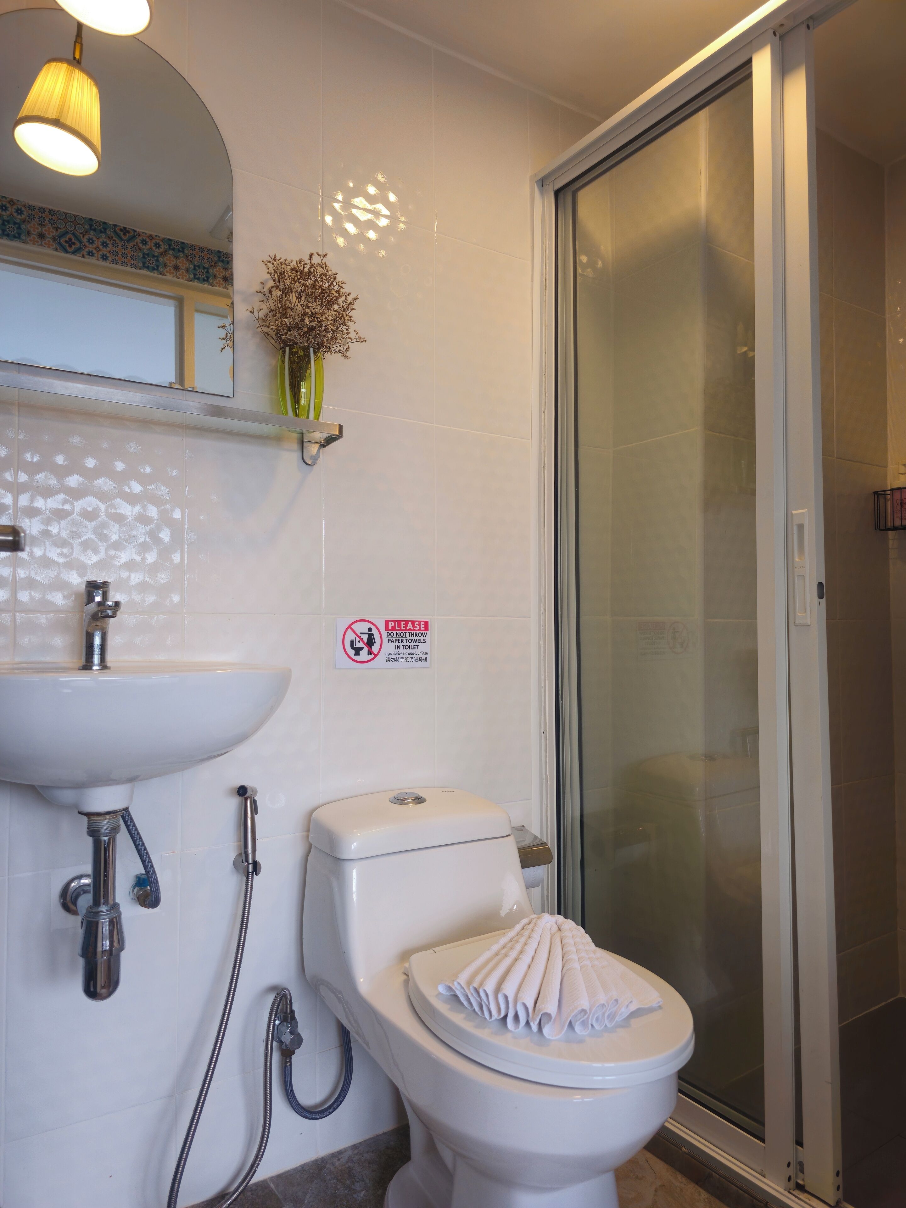 Un baño con lavamanos, inodoro y ducha.