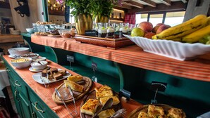A buffet with various food items, including cakes, pastries, and fruits. - La Noi Guesthouse (Grevena)