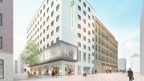 A modern hotel with a prominent Holiday Inn Express sign, large windows, and a spacious outdoor area with people walking. - Holiday Inn Express Recklinghausen by IHG (Recklinghausen)