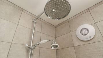 A shower with a handheld showerhead and a wall-mounted rain showerhead.