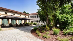 A building with outdoor seating and a gravel path. - Hotel Ristorante Magia del Brenta (Fiesso d'Artico)