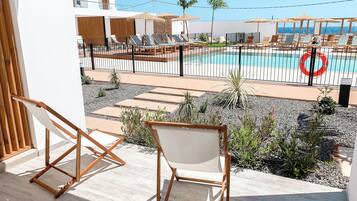 A poolside area with lounge chairs and a view of the pool.