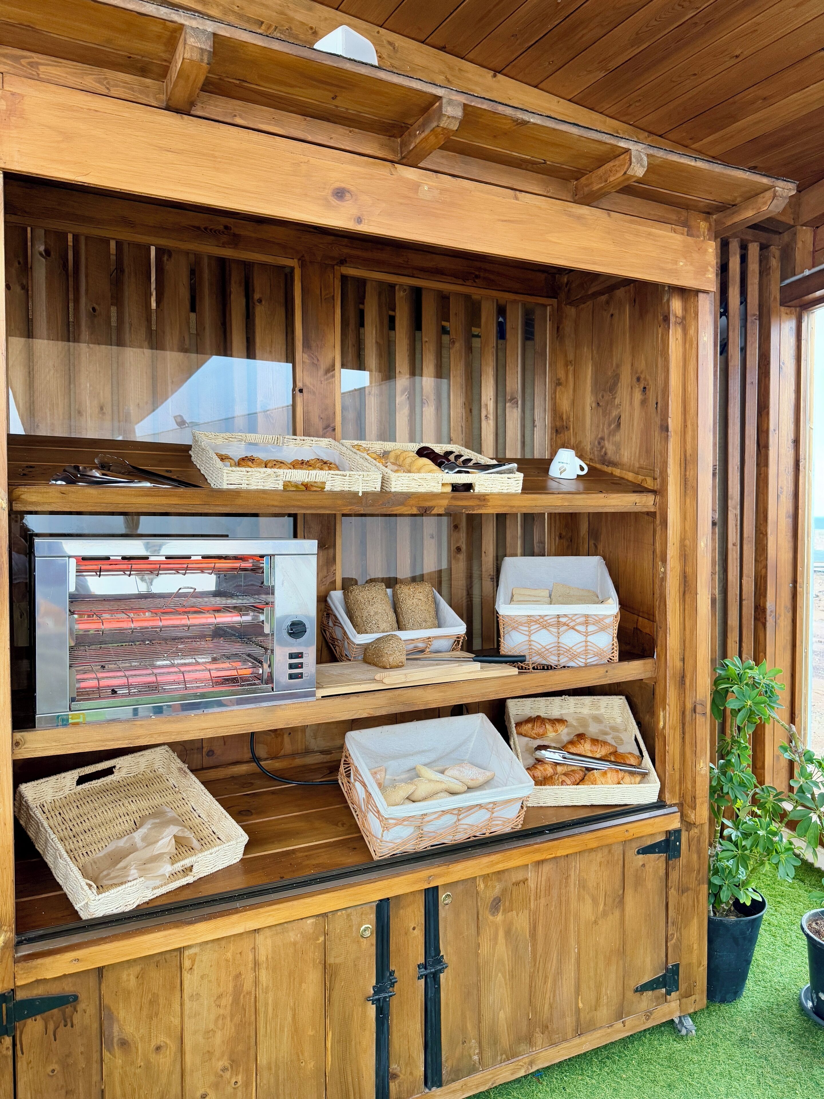 Une vitrine en bois où sont exposés divers produits de boulangerie et un four à pain.