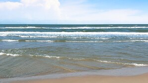 A beach with waves and a clear sky. - Amazing Bay View, Boat docks, and easy walk to the beach (South Padre Island)