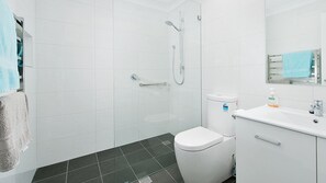 Un baño con ducha, inodoro y lavabo.