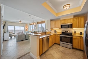 A modern kitchen with wooden cabinets, stainless steel appliances, and a large island.