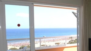 A balcony with a view of the sea and beach.