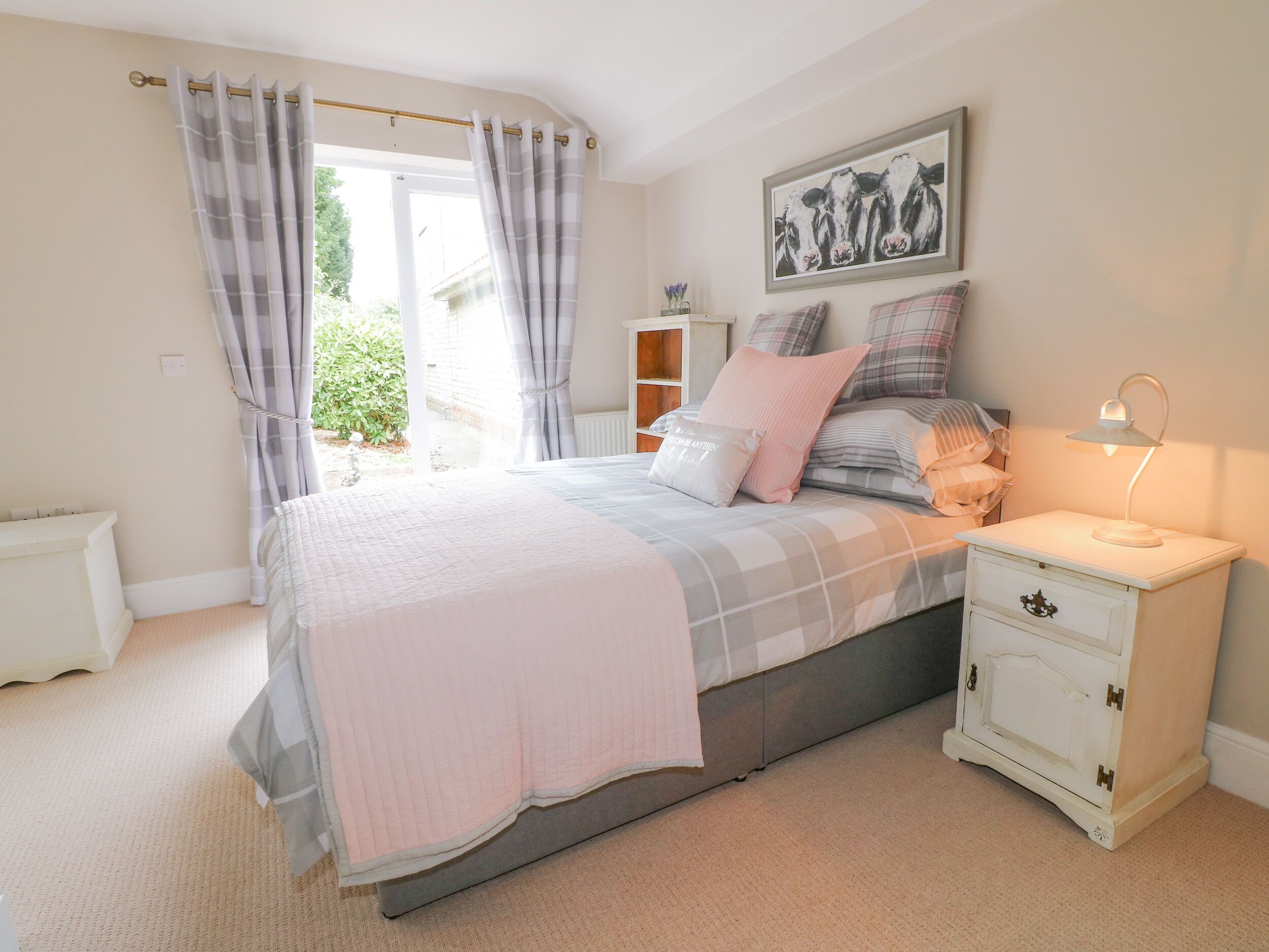 A bedroom with a bed, bedside table, and a nightstand.