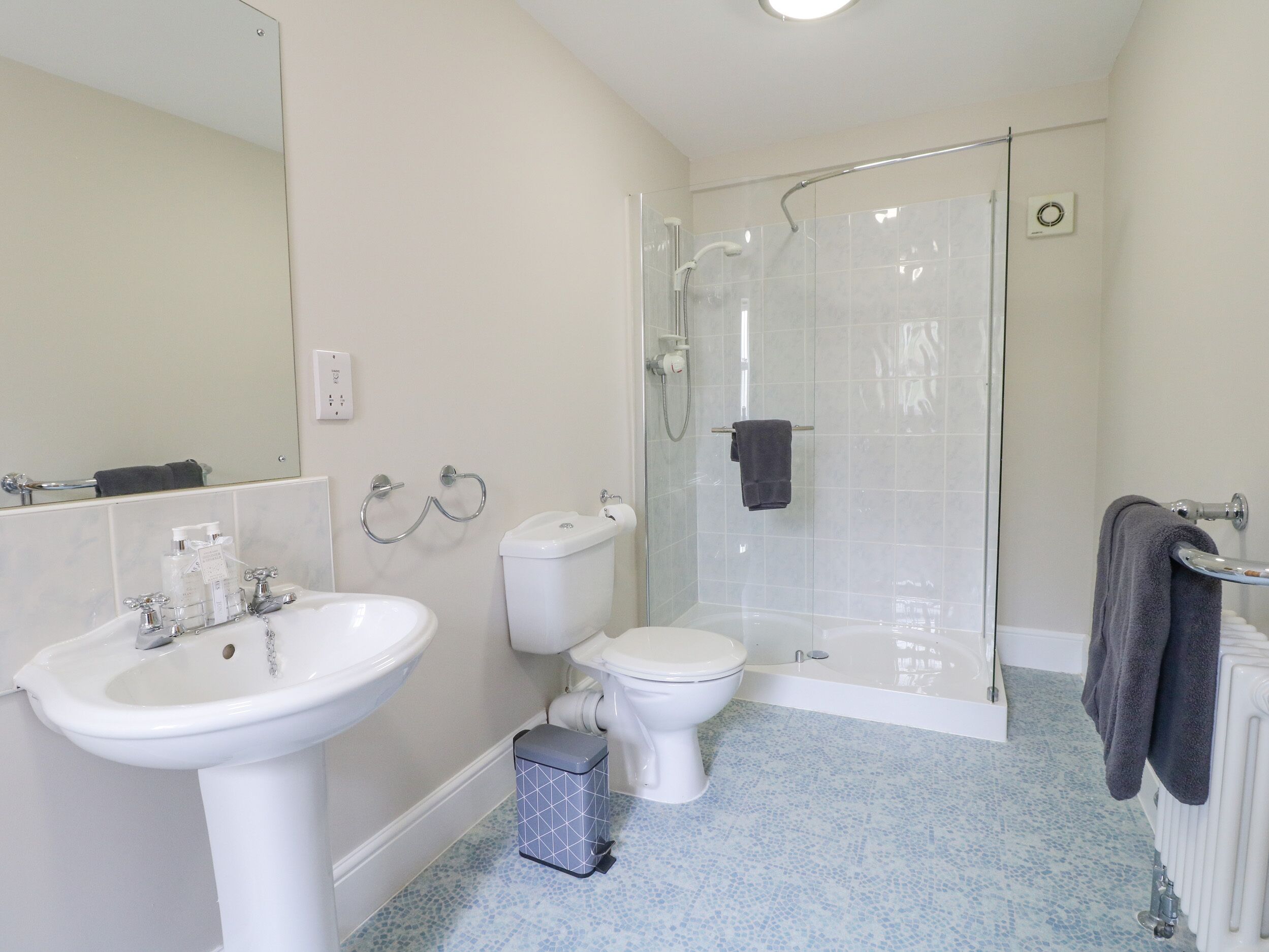 Un baño con lavamanos, inodoro y ducha.