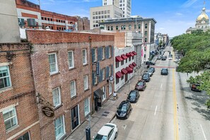 A street view of a city with a row of brick buildings, including a hotel with a sign that reads "Oglethorpe Lodge."