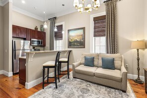 A modern kitchen with a built-in microwave, a refrigerator, and wooden cabinets. - Charming Downtown Studio One Block From The River by Lucky Savannah (Savannah)