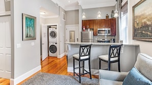 A modern kitchen with a central island, bar stools, and a built-in oven. - Charming Downtown Studio One Block From The River by Lucky Savannah (Savannah)