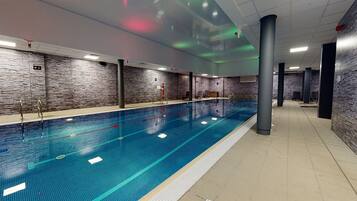 Una piscina techada, sillones reclinables de piscina