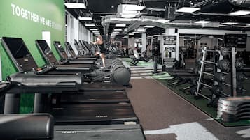 A gym with treadmills, weight machines, and a motivational wall.