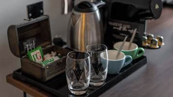 A tray with two glasses, a coffee pot, a box of PG cigarettes, and a mug on a wooden table.