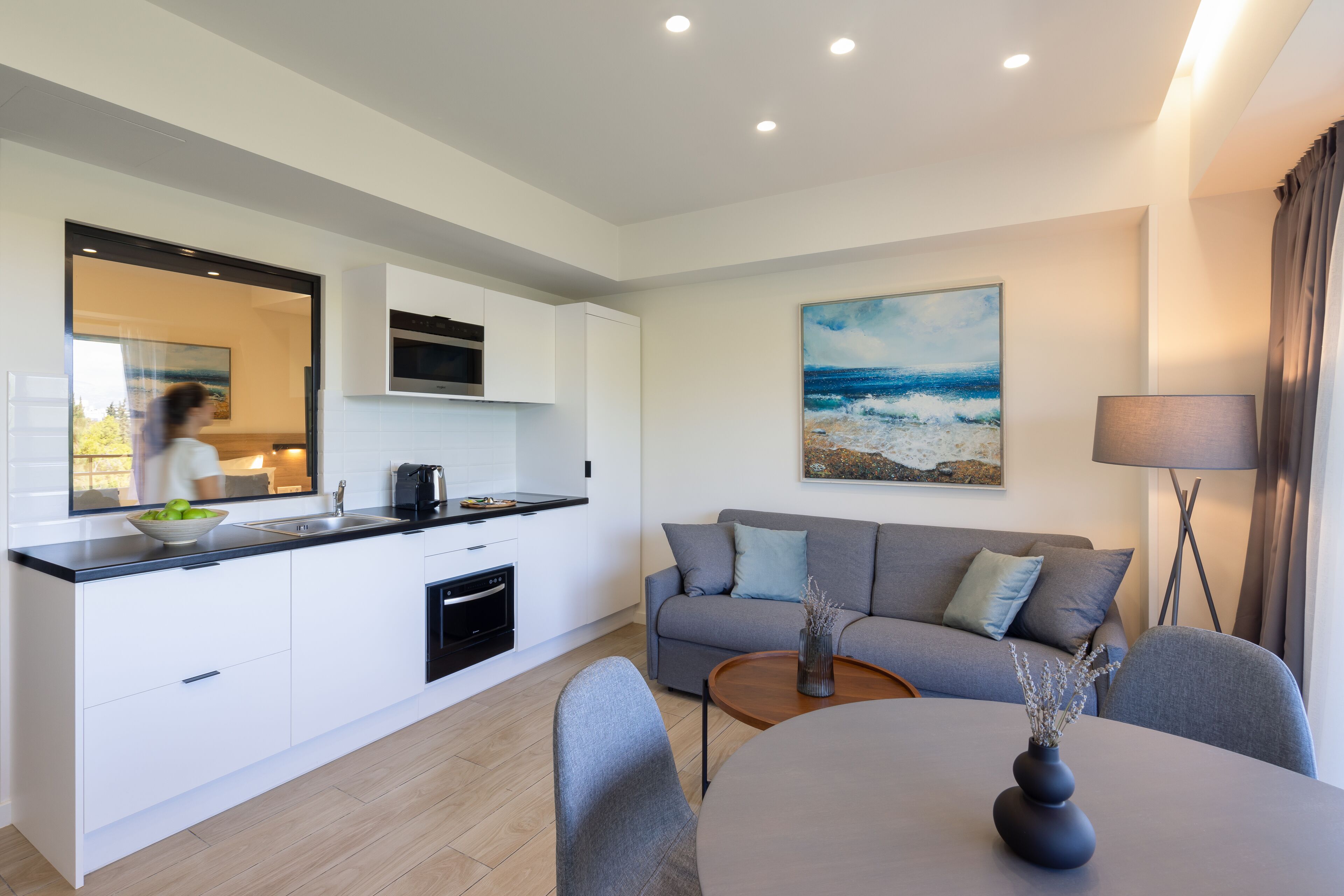 A modern living space with a kitchen, dining area, and a sofa.